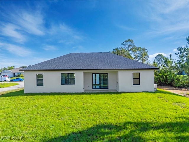 3115 41st St SW, Lehigh Acres, FL 33976 - rear view of house featuring stucco siding, a yard, and roof with shingles