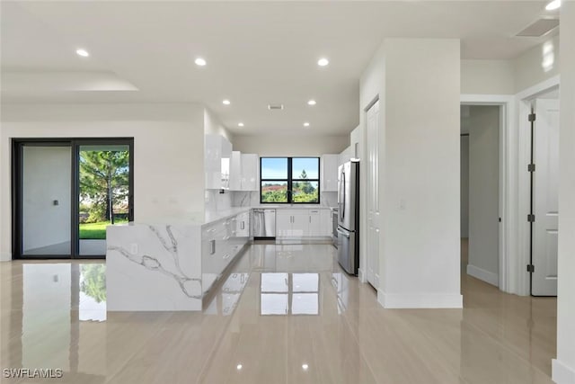 3115 41st St SW, Lehigh Acres, FL 33976 - kitchen featuring appliances with stainless steel finishes, white cabinetry, light stone countertops, recessed lighting, and light tile patterned flooring