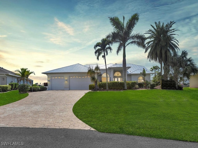 2546 SW 45th St, Cape Coral, FL 33914 - view of front of house featuring decorative driveway, a yard, and a metal roof