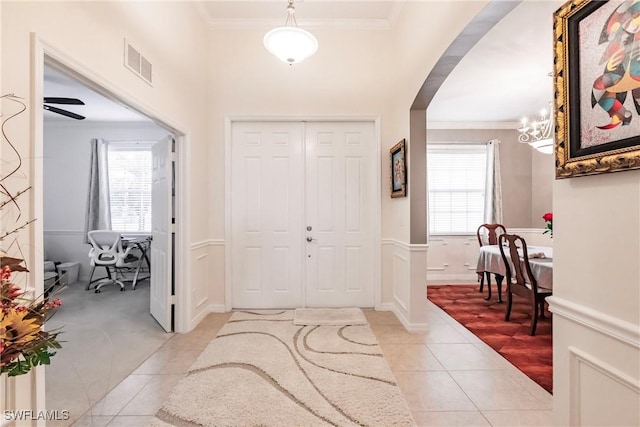 3260 Magnolia Landing Ln, North Fort Myers, FL 33917 - entrance foyer with light tile patterned floors, arched walkways, crown molding, plenty of natural light, and a chandelier