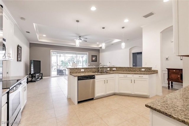 3260 Magnolia Landing Ln, North Fort Myers, FL 33917 - kitchen with appliances with stainless steel finishes, arched walkways, a tray ceiling, a ceiling fan, and light stone counters