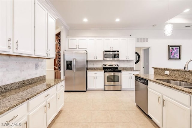3260 Magnolia Landing Ln, North Fort Myers, FL 33917 - kitchen featuring appliances with stainless steel finishes, decorative backsplash, white cabinets, decorative light fixtures, and crown molding