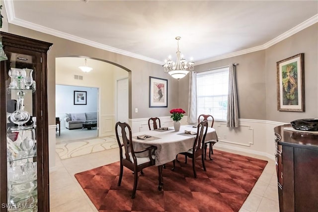 3260 Magnolia Landing Ln, North Fort Myers, FL 33917 - tiled dining room with arched walkways, ornamental molding, a chandelier, a decorative wall, and wainscoting