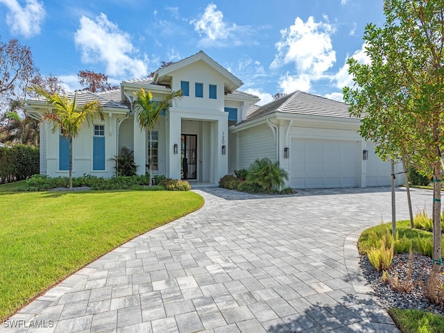 130 Burning Tree Dr, Naples, FL 34105 - view of front of home with a tiled roof, decorative driveway, a garage, a front yard, and stucco siding