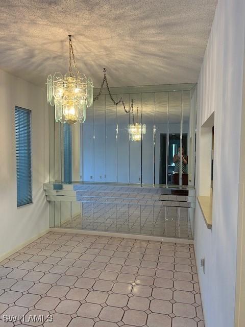 9950 Sailview Ct Unit 12, Fort Myers, FL 33905 - spare room with a chandelier, a textured ceiling, and tile patterned floors