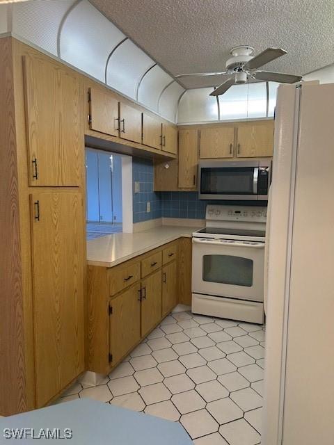 9950 Sailview Ct Unit 12, Fort Myers, FL 33905 - kitchen with white appliances, a ceiling fan, light countertops, a textured ceiling, and light flooring