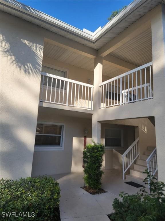 709 Landover Cir Unit 203, Naples, FL 34104 - view of property exterior with stucco siding and a balcony