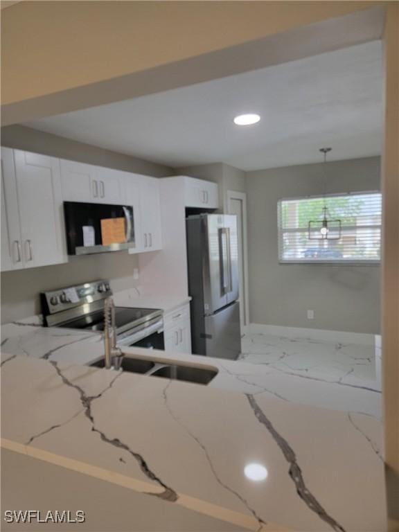 709 Landover Cir Unit 203, Naples, FL 34104 - kitchen with stainless steel appliances, white cabinetry, recessed lighting, light stone counters, and marble look tile flooring