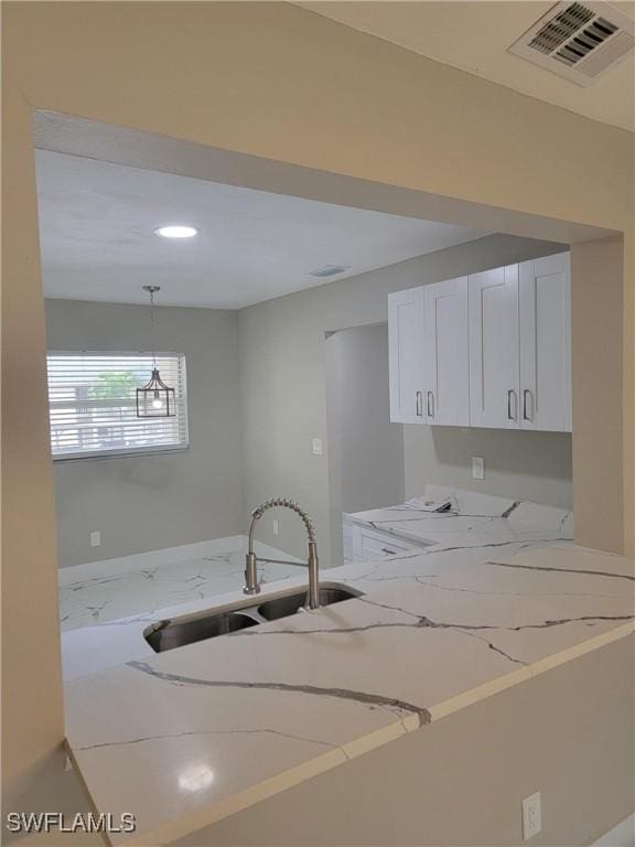 709 Landover Cir Unit 203, Naples, FL 34104 - kitchen featuring light stone counters, white cabinets, decorative light fixtures, and recessed lighting
