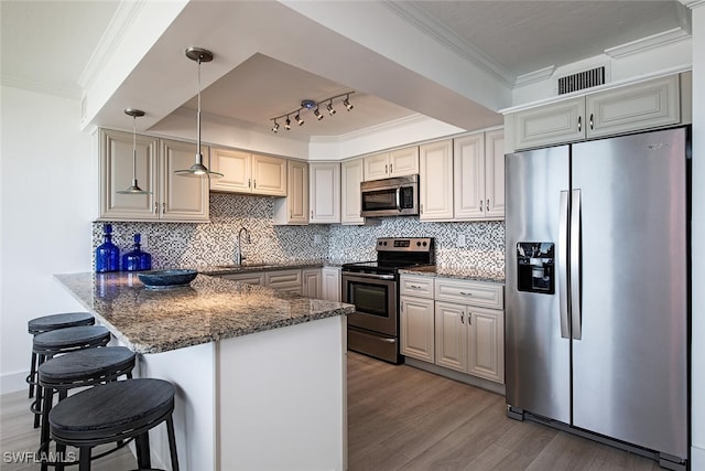 9375 Gulf Shore Dr Unit 402, Naples, FL 34108 - kitchen featuring appliances with stainless steel finishes, ornamental molding, wood finished floors, a peninsula, and a breakfast bar