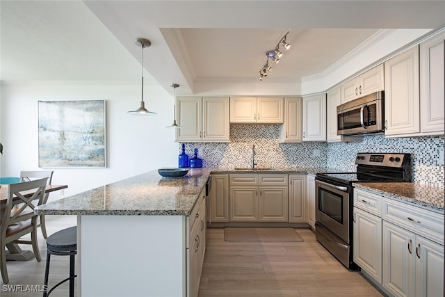 9375 Gulf Shore Dr Unit 402, Naples, FL 34108 - kitchen with appliances with stainless steel finishes, a peninsula, dark stone countertops, light wood-style flooring, and tasteful backsplash
