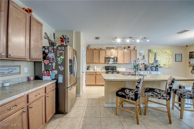 1817 SW 3rd Ave, Cape Coral, FL 33991 - kitchen featuring appliances with stainless steel finishes, a breakfast bar, light countertops, light tile patterned floors, and a kitchen island with sink