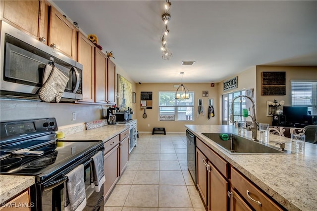 1817 SW 3rd Ave, Cape Coral, FL 33991 - kitchen with black appliances, brown cabinetry, light countertops, and hanging light fixtures