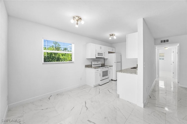 601 Periwinkle Way Unit D1, Sanibel, FL 33957 - kitchen with white appliances, white cabinets, light marble finish flooring, and light stone countertops
