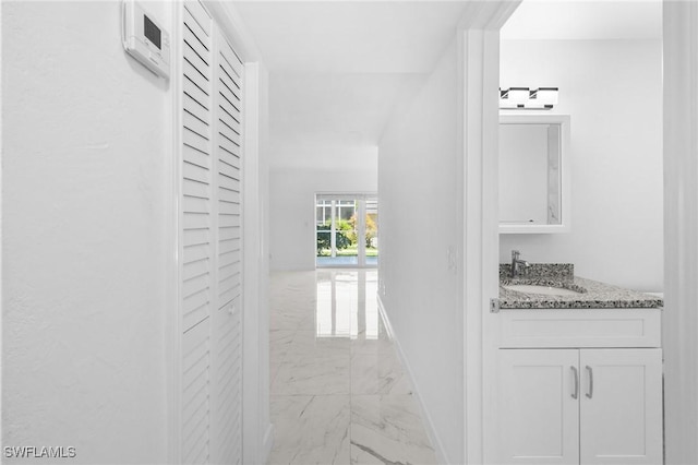 601 Periwinkle Way Unit D1, Sanibel, FL 33957 - hallway featuring light marble finish floors and a sink