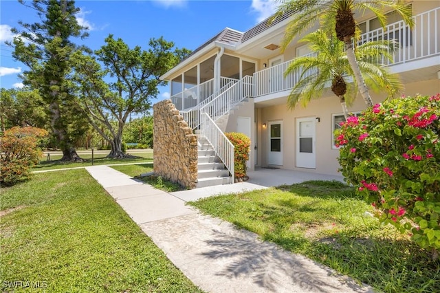 601 Periwinkle Way Unit D1, Sanibel, FL 33957 - doorway to property with stucco siding and a yard