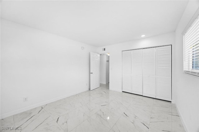 601 Periwinkle Way Unit D1, Sanibel, FL 33957 - unfurnished bedroom featuring marble look tile flooring, a closet, and recessed lighting