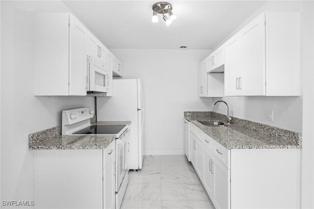 601 Periwinkle Way Unit D1, Sanibel, FL 33957 - kitchen featuring white appliances, light marble finish floors, white cabinetry, and light stone counters