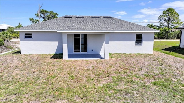 2817 43rd St W, Lehigh Acres, FL 33971 - back of house with stucco siding, a shingled roof, a yard, and a patio area