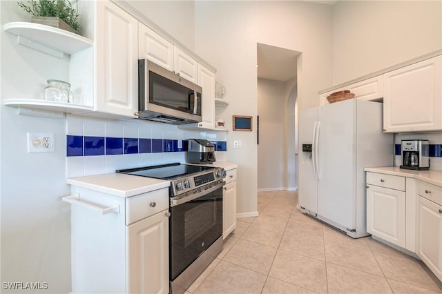 6325 Wilshire Pines Cir Unit 3, Naples, FL 34109 - kitchen with stainless steel appliances, open shelves, tasteful backsplash, and white cabinets