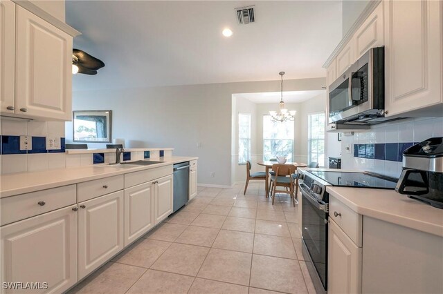 6325 Wilshire Pines Cir Unit 3, Naples, FL 34109 - kitchen featuring stainless steel appliances, decorative backsplash, a chandelier, white cabinets, and recessed lighting