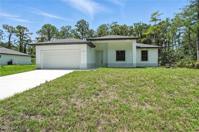 1002 E 17th St, Lehigh Acres, FL 33972 - prairie-style house with an attached garage, driveway, a front yard, stucco siding, and roof with shingles
