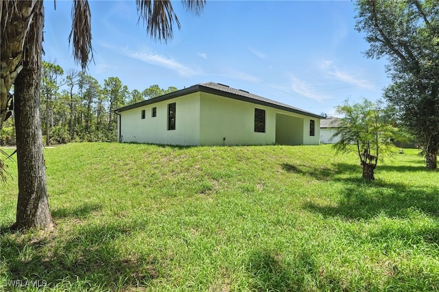 1002 E 17th St, Lehigh Acres, FL 33972 - view of side of home featuring stucco siding and a lawn