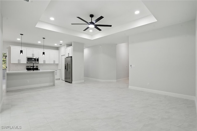 1002 E 17th St, Lehigh Acres, FL 33972 - unfurnished living room with ceiling fan, recessed lighting, and a raised ceiling