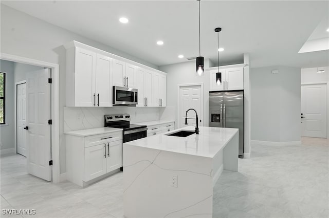 1002 E 17th St, Lehigh Acres, FL 33972 - kitchen with appliances with stainless steel finishes, recessed lighting, pendant lighting, white cabinets, and a kitchen island with sink