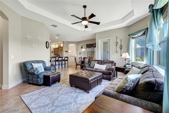 9693 Cobalt Cove Cir, Naples, FL 34120 - living area featuring arched walkways, a raised ceiling, a ceiling fan, and light tile patterned floors