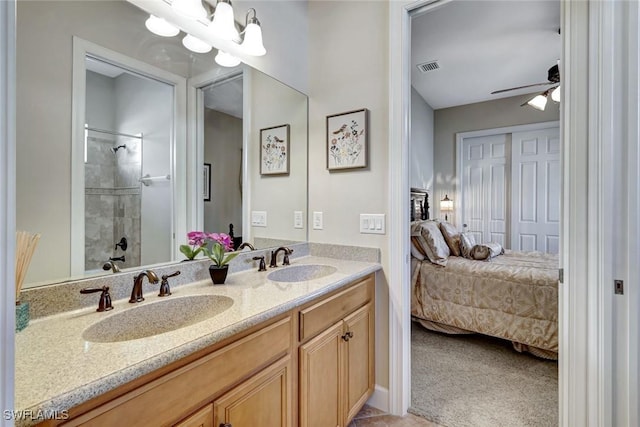 9693 Cobalt Cove Cir, Naples, FL 34120 - bathroom featuring connected bathroom, double vanity, a tile shower, and a ceiling fan