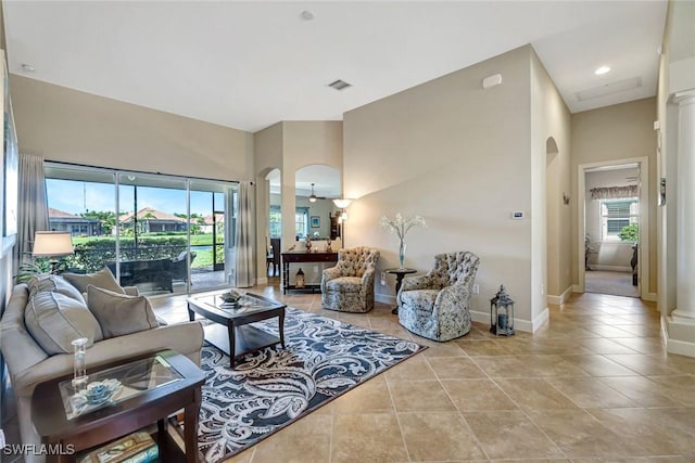 9693 Cobalt Cove Cir, Naples, FL 34120 - living area with arched walkways, light tile patterned floors, a high ceiling, and ornate columns