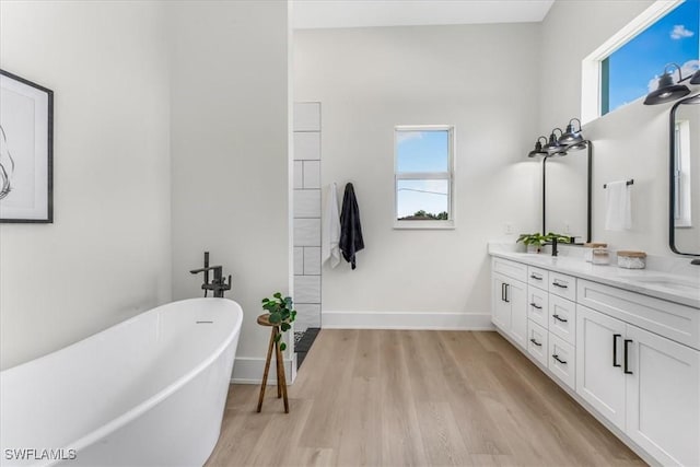 3548 Mondovi Ct, Punta Gorda, FL 33950 - full bath featuring a freestanding tub, wood finished floors, double vanity, and healthy amount of natural light