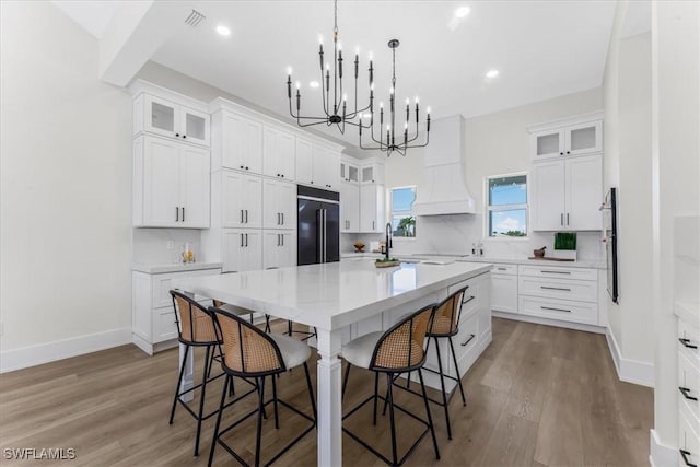 3548 Mondovi Ct, Punta Gorda, FL 33950 - kitchen with high end black fridge, a chandelier, a kitchen breakfast bar, a large island, and wood finished floors