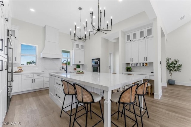 3548 Mondovi Ct, Punta Gorda, FL 33950 - kitchen featuring a large island, white cabinetry, a kitchen bar, stainless steel double oven, and recessed lighting