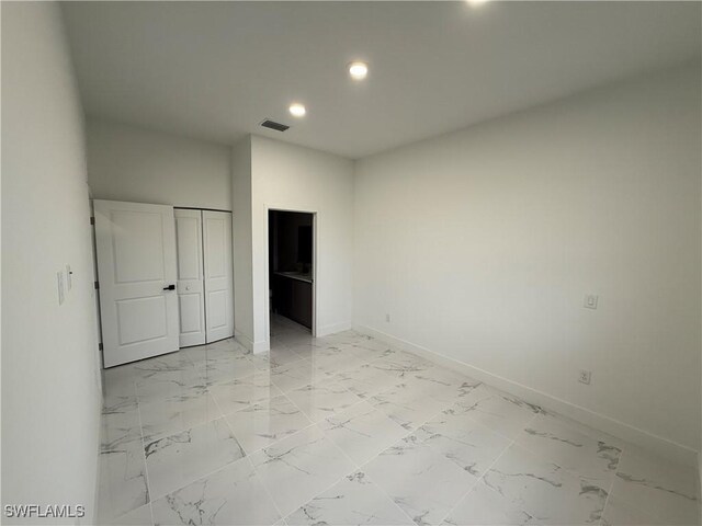 2035 NE 9th Ave, Cape Coral, FL 33909 - unfurnished bedroom with recessed lighting, light marble finish floors, and a closet