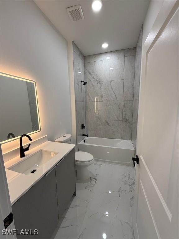 2035 NE 9th Ave, Cape Coral, FL 33909 - bathroom featuring vanity, marble look tiles, tub / shower combination, and recessed lighting