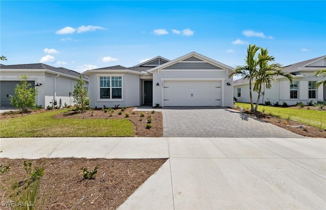 604 Oasis Lake Pl, Lehigh Acres, FL 33936 - ranch-style home with decorative driveway, an attached garage, a front lawn, and stucco siding