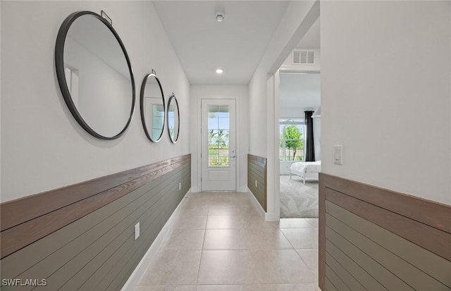 604 Oasis Lake Pl, Lehigh Acres, FL 33936 - hallway with light tile patterned floors, a wainscoted wall, and recessed lighting