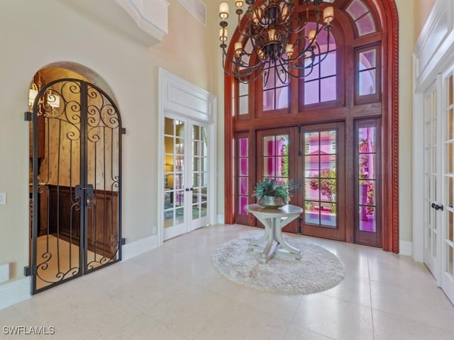 504 Tigertail Ct, Marco Island, FL 34145 - tiled foyer with french doors, a towering ceiling, and a chandelier