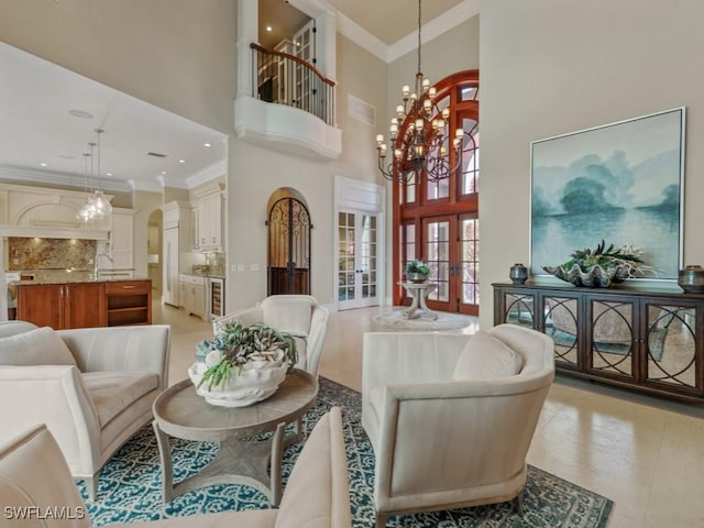 504 Tigertail Ct, Marco Island, FL 34145 - living room with a chandelier, french doors, a high ceiling, ornamental molding, and arched walkways