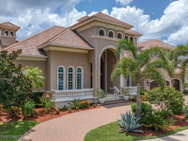 504 Tigertail Ct, Marco Island, FL 34145 - mediterranean / spanish house featuring covered porch, stucco siding, decorative driveway, and a tile roof