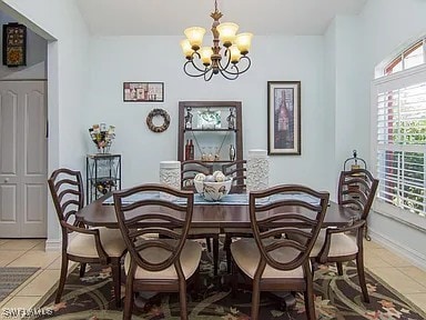 27329 Jolly Roger Ln, Bonita Springs, FL 34135 - dining room with a chandelier, healthy amount of natural light, and light tile patterned floors