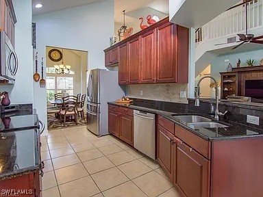 27329 Jolly Roger Ln, Bonita Springs, FL 34135 - kitchen with stainless steel appliances, a ceiling fan, light tile patterned floors, dark stone countertops, and recessed lighting