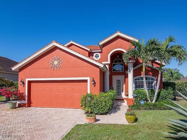 27329 Jolly Roger Ln, Bonita Springs, FL 34135 - view of front of property with a garage, stucco siding, decorative driveway, and a front yard