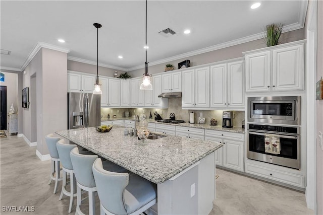 2786 Aviamar Cir, Naples, FL 34114 - kitchen with appliances with stainless steel finishes, white cabinetry, an island with sink, light stone countertops, and a breakfast bar area