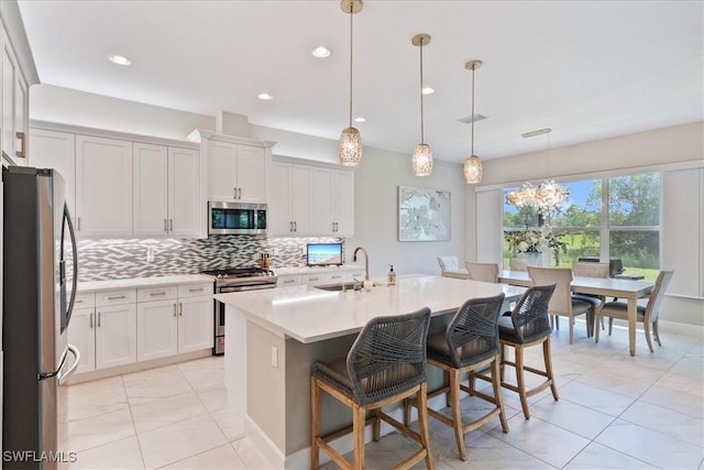 28646 Lobos Cir, Bonita Springs, FL 34135 - kitchen featuring stainless steel appliances, backsplash, light countertops, white cabinets, and recessed lighting