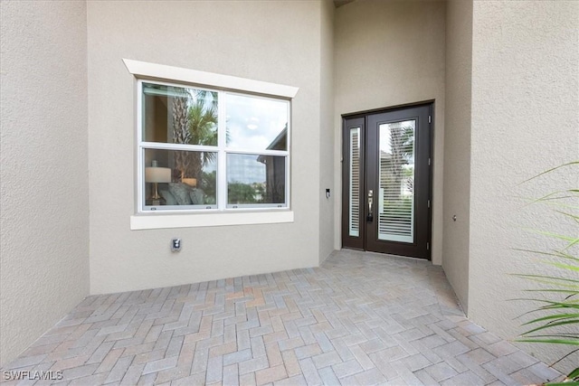28646 Lobos Cir, Bonita Springs, FL 34135 - doorway to property with stucco siding and a patio area