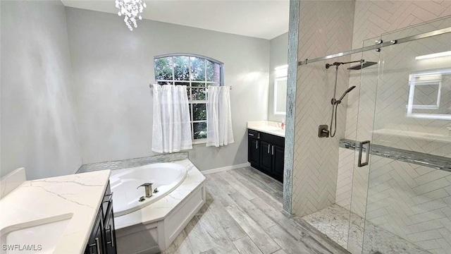 3940 Ruxton Rd, Naples, FL 34116 - full bathroom featuring vanity, a garden tub, a stall shower, and wood finished floors