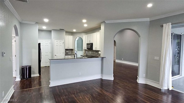 3940 Ruxton Rd, Naples, FL 34116 - kitchen with arched walkways, ornamental molding, black microwave, dark wood finished floors, and white cabinets